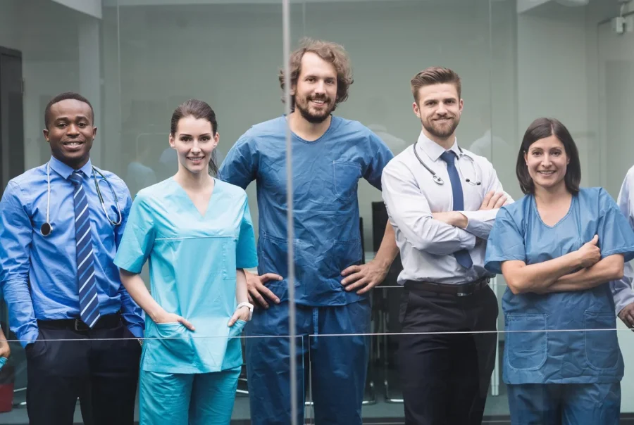 Team of healthcare professionals recruited by a nursing agency smiling at the camera.